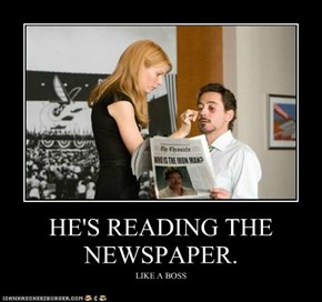 HE'S READING THE NEWSPAPER.
